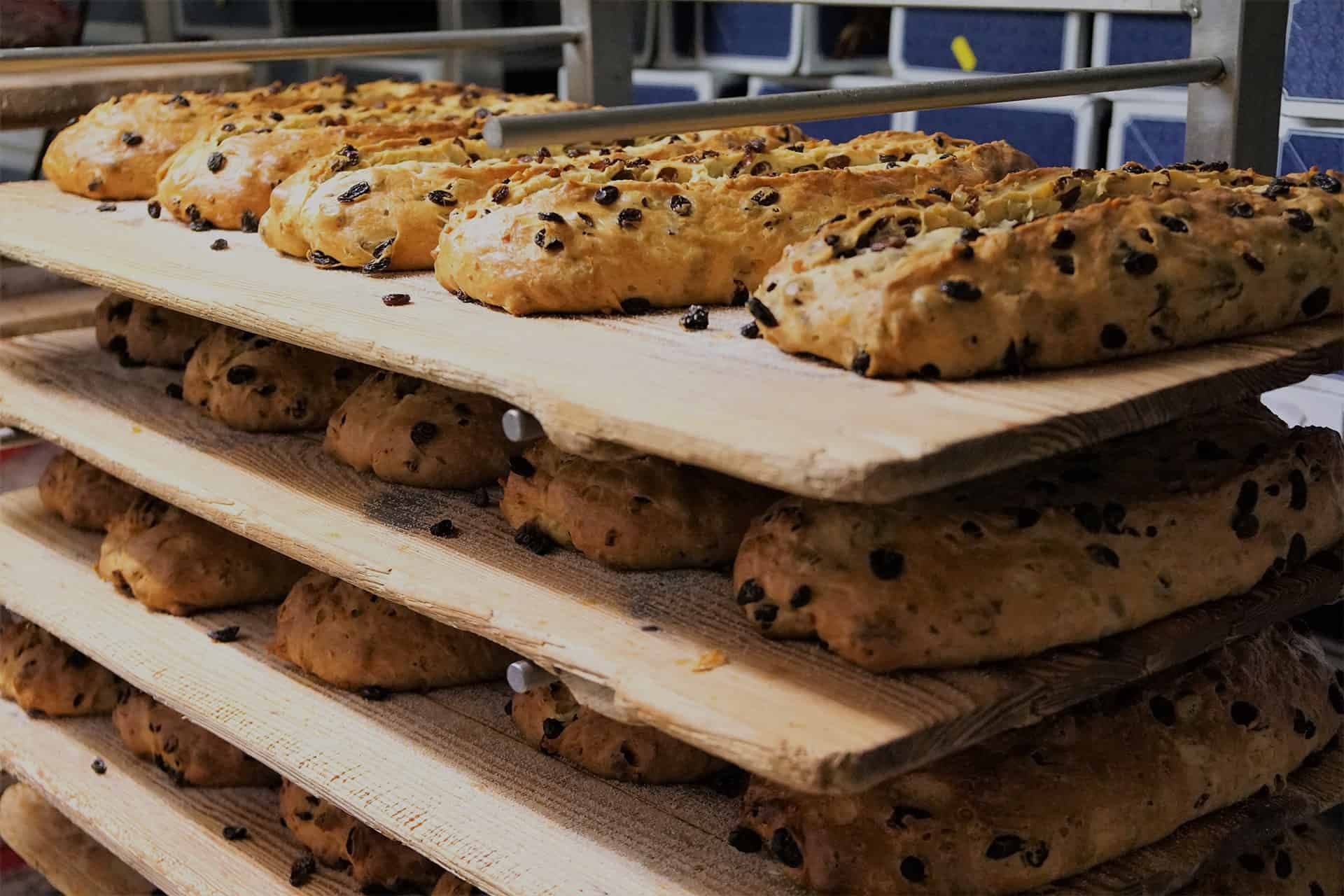 Frisch gebackene Stollen auf Holzbrettern in der Backstube